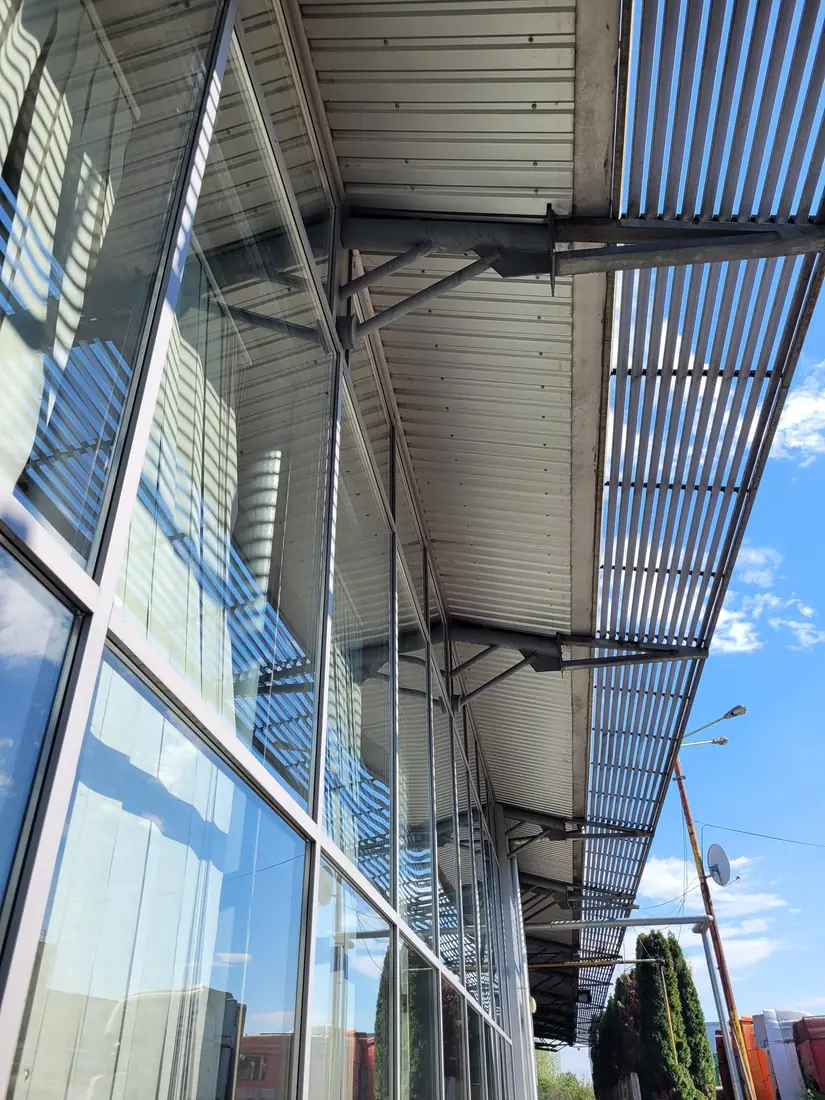Fațada de sticlă a showroom-ului, sub copertina metalică